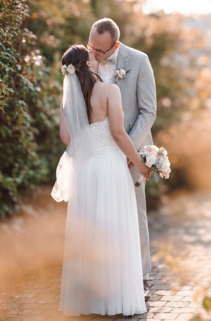 Brautpaar küsst sich beim Hochzeitsportrait im warmen Abendlicht – natürliche Hochzeitsfotografie NRW