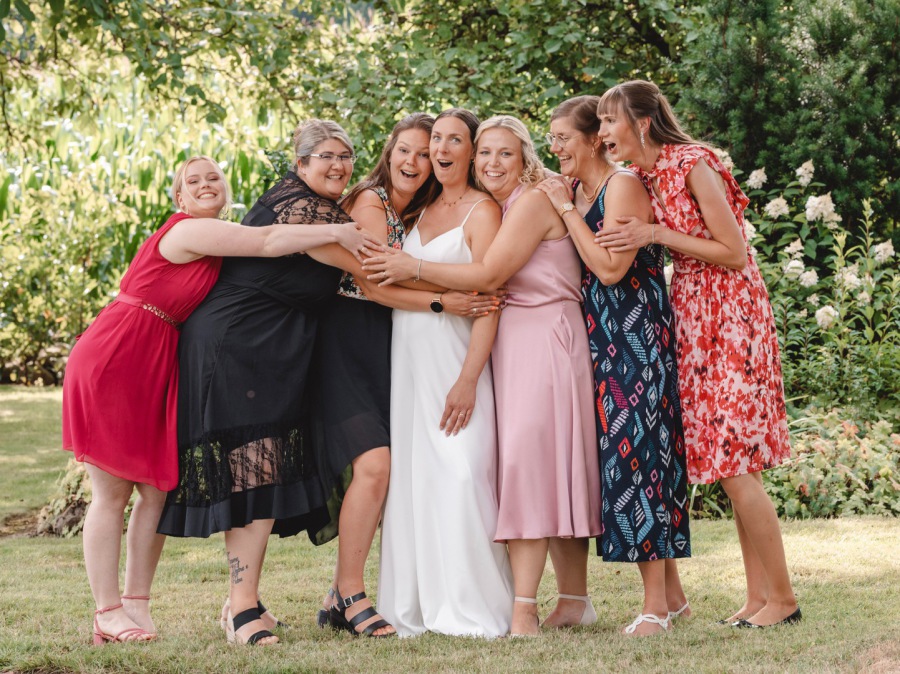 Braut mit Freundinnen beim Empfang – fröhliches Gruppenfoto in natürlicher Hochzeitsreportage
