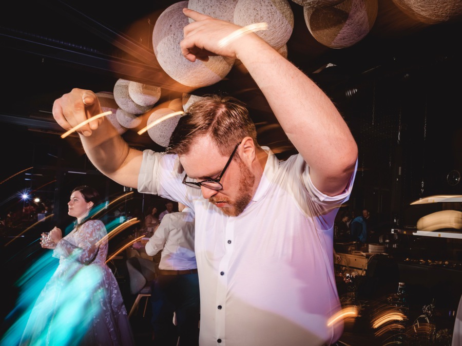Hochzeitsgäste feiern und tanzen auf der Party, lebendige Reportagefotografie mit Bewegung und Licht in der Werkstatt Mettingen